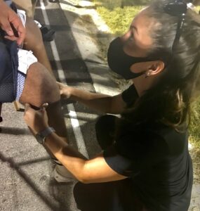PA examining knee during football game