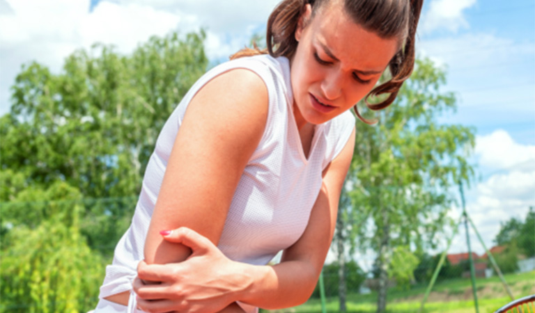 Woman suffering from tennis elbow pain